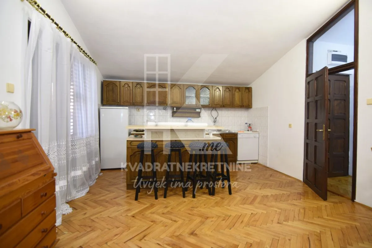 Kitchen with wooden cabinetry, a breakfast bar, and parquet flooring.