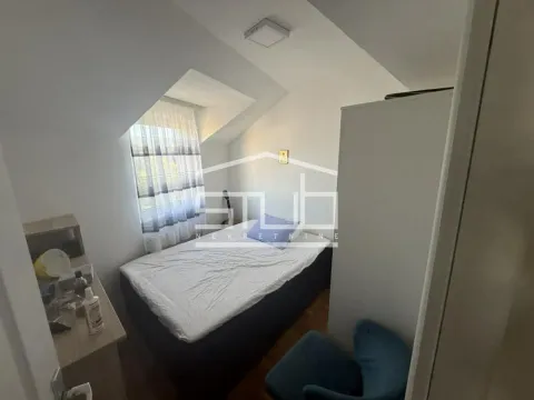 Smaller bedroom with a bed and a slanted roof window in the attic. - image 4