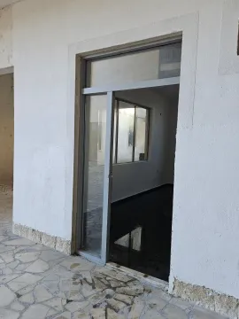 Entrance to a commercial space with glass doors and a paved courtyard. - image 9