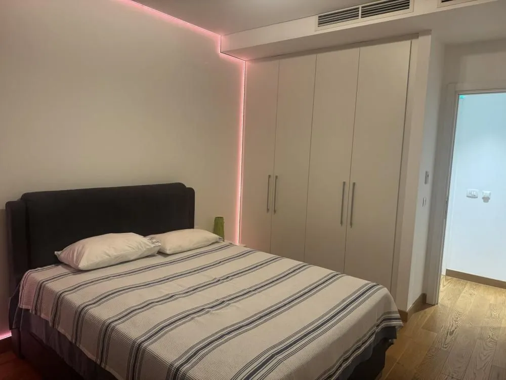 Modern bedroom with a double bed and a fitted wardrobe.