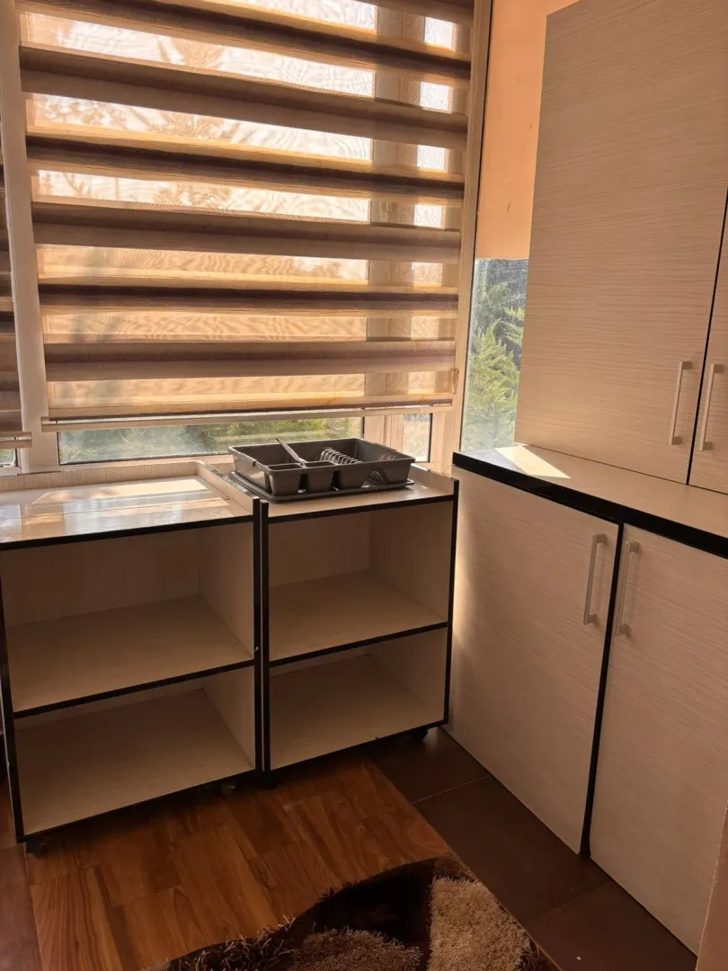 Small kitchen space with cabinetry and a window.