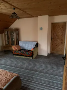 Dnevna soba sa drvenim plafonom, kaučem i vitrinom u potkrovlju. - image 15