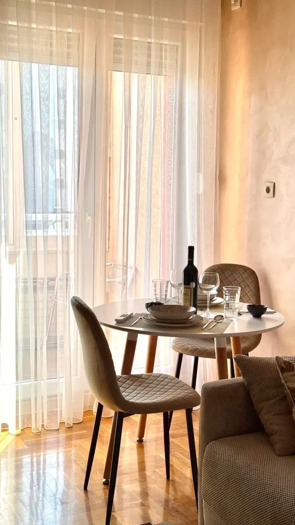 Dining table with chairs by the window in the living room.