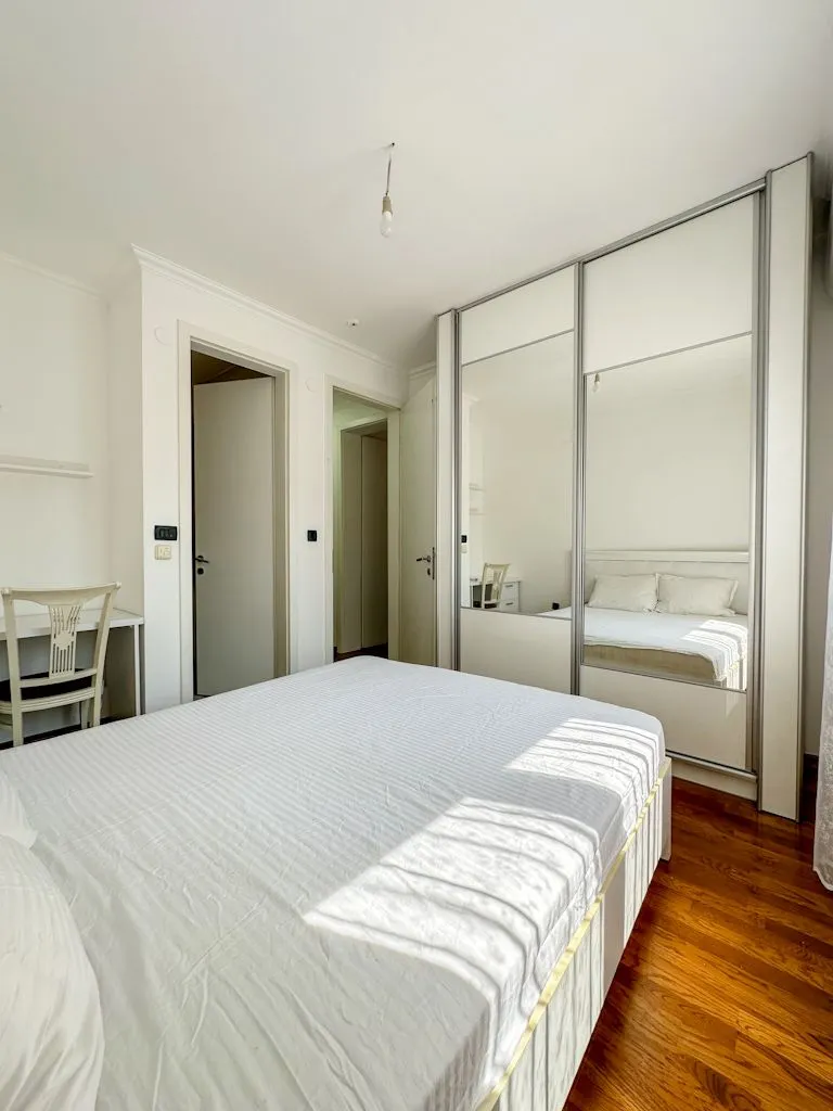 Bright and tidy bedroom with a double bed and a large wardrobe.