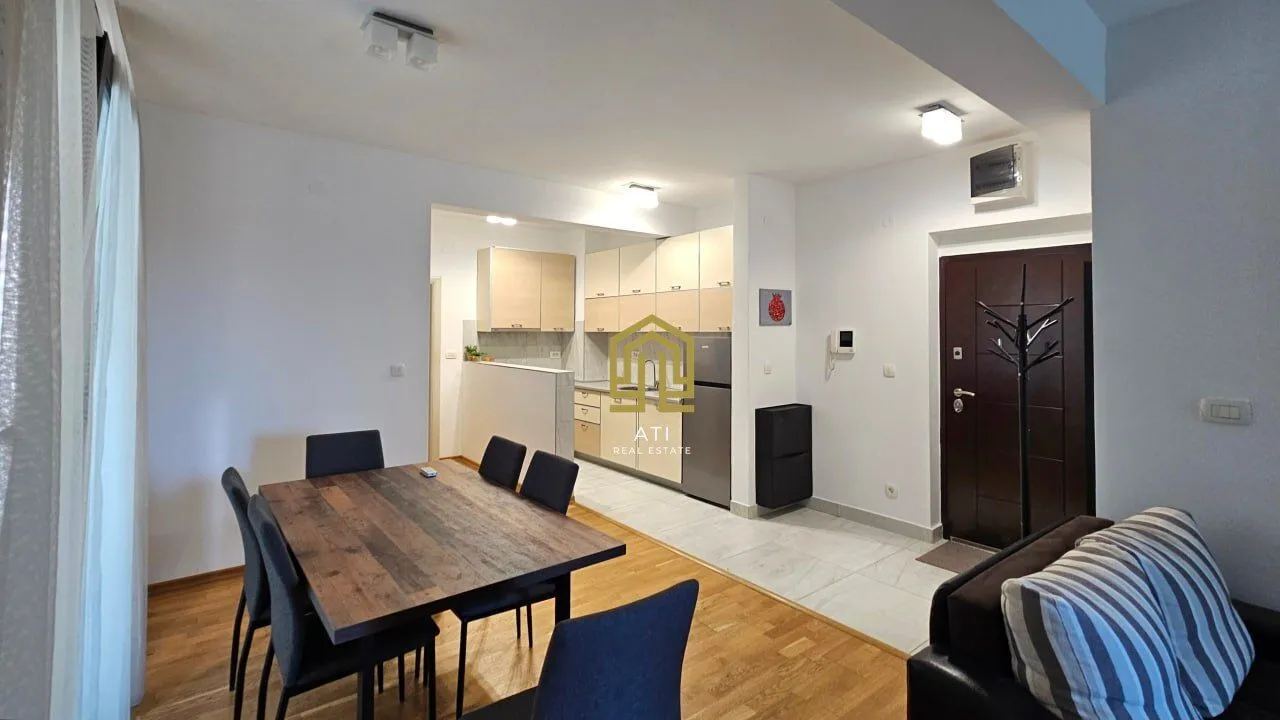 Living room with dining area and kitchen in the background.