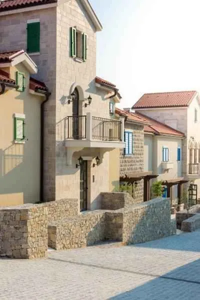 Pogled na spoljašnost tradicionalno građene zgrade sa kamenom fasadom i balkonima.