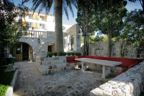 Stone courtyard with outdoor seating and a palm tree in front of a stone house. - image 15