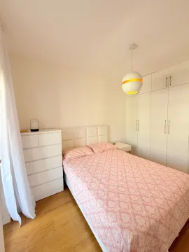 Svjetla i uredna spavaća soba sa bračnim krevetom, bijelim ormarom i komodom. - image 10