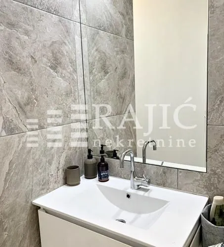 Modernly equipped bathroom with a washbasin and mirror.