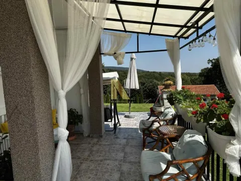 Natkrivena terasa sa garniturom za sedenje i pogledom na dvorište. - image 13