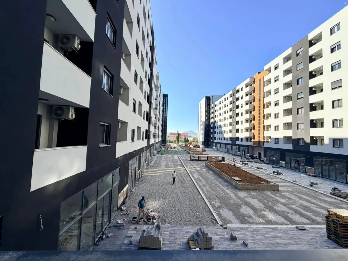 Pogled na dvorište i fasadu stambenih zgrada u izgradnji.