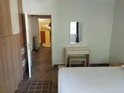 Furnished bedroom with a double bed, wardrobe, and mirror. - image 10