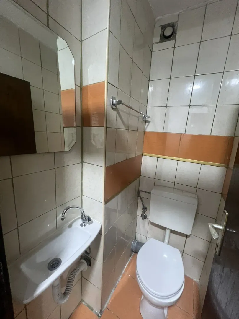 Malo kupatilo sa lavaboom, ogledalom i toaletom.
