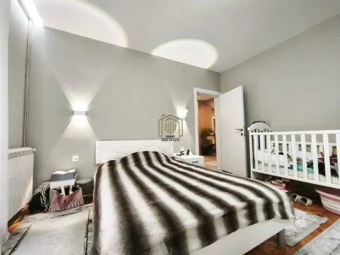 Furnished bedroom with a double bed and a baby crib. - image 4