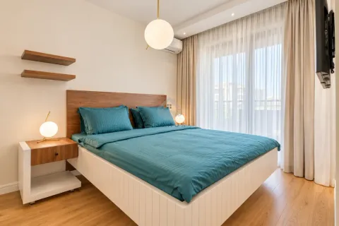 Modern bedroom with a double bed, bedside tables, and a large window. - image 18
