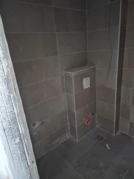 Bathroom under final construction with tiles and plumbing installations. - image 30