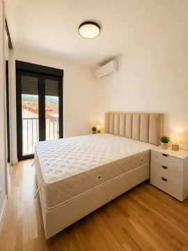 Svijetla spavaća soba sa bračnim krevetom i noćnim ormarićem. - image 3