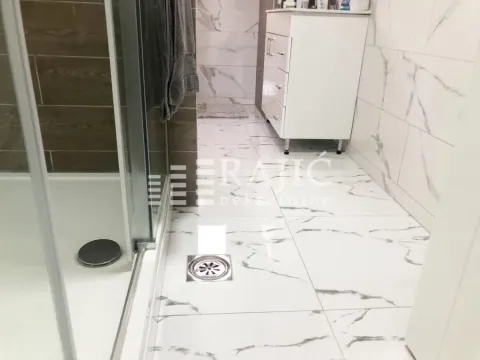 Modern bathroom with a shower cabin and white marble tiles. - image 12