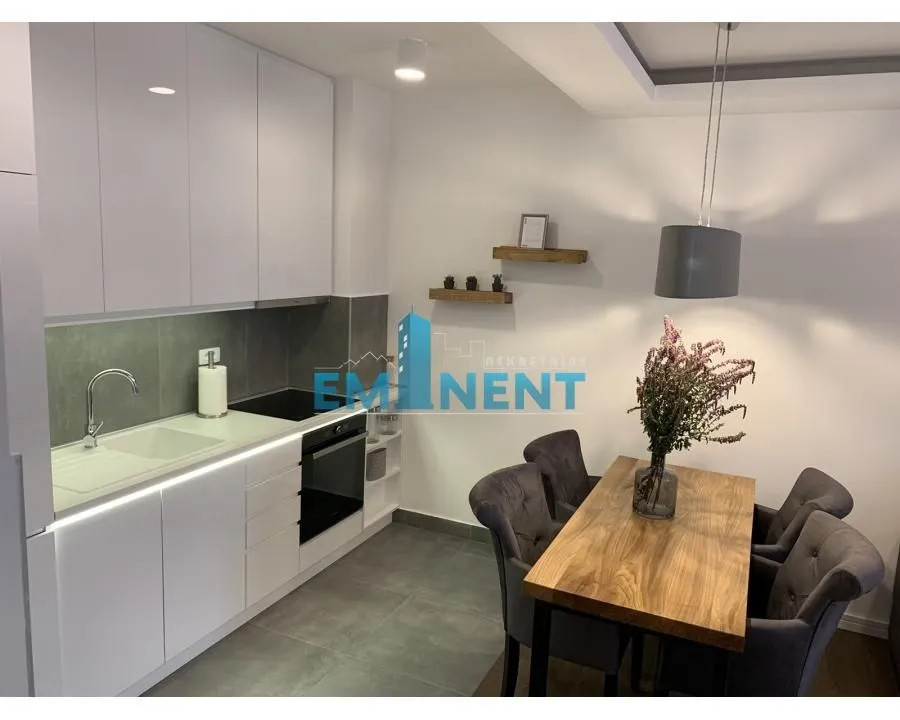 Modern kitchen with white cabinetry and a dining table with chairs.