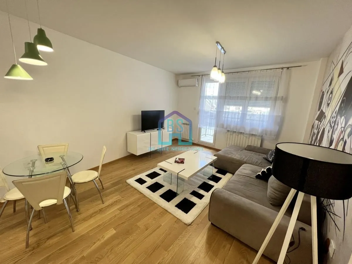 Living room with a sofa, dining table, and access to the terrace.