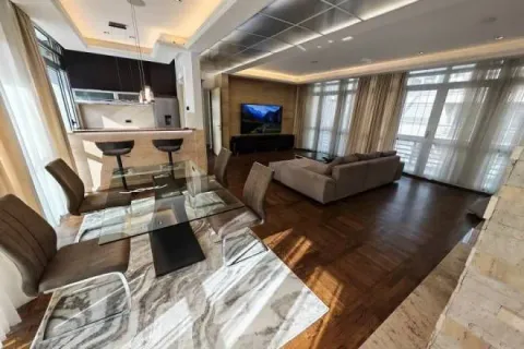 Spacious living room with a dining area and kitchen in the background. - image 2