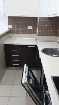 Manja kuhinja sa tamnim elementima i svijetlim radnim površinama. - image 4