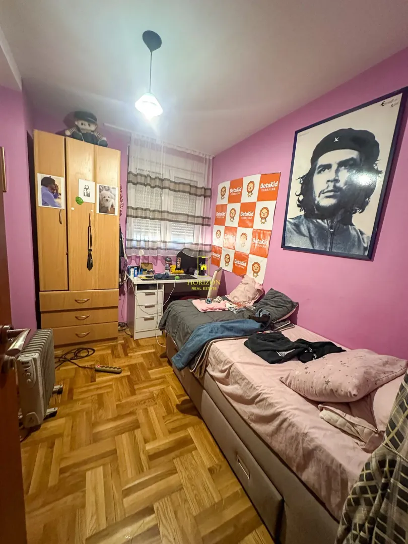 Dječija soba sa krevetom, ormarom i radnim stolom.