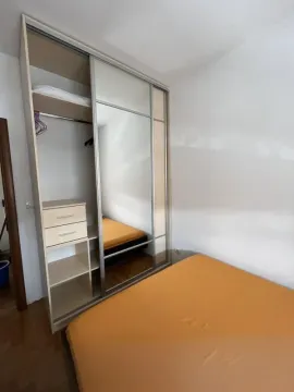 Bedroom featuring a large built-in wardrobe with sliding doors and a double bed. - image 12