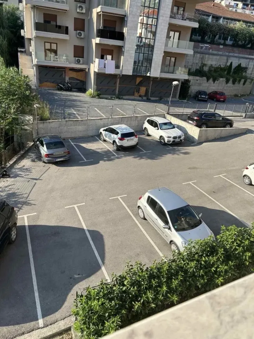 Pogled sa terase na parking prostor i zgradu.