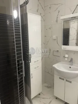 Modern bathroom with a shower cabin, washbasin, and white cabinetry. - image 19
