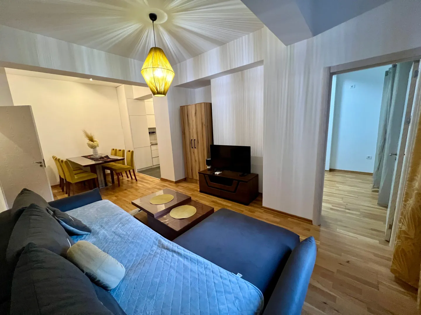 Spacious living room with a sofa set and dining area in the background.