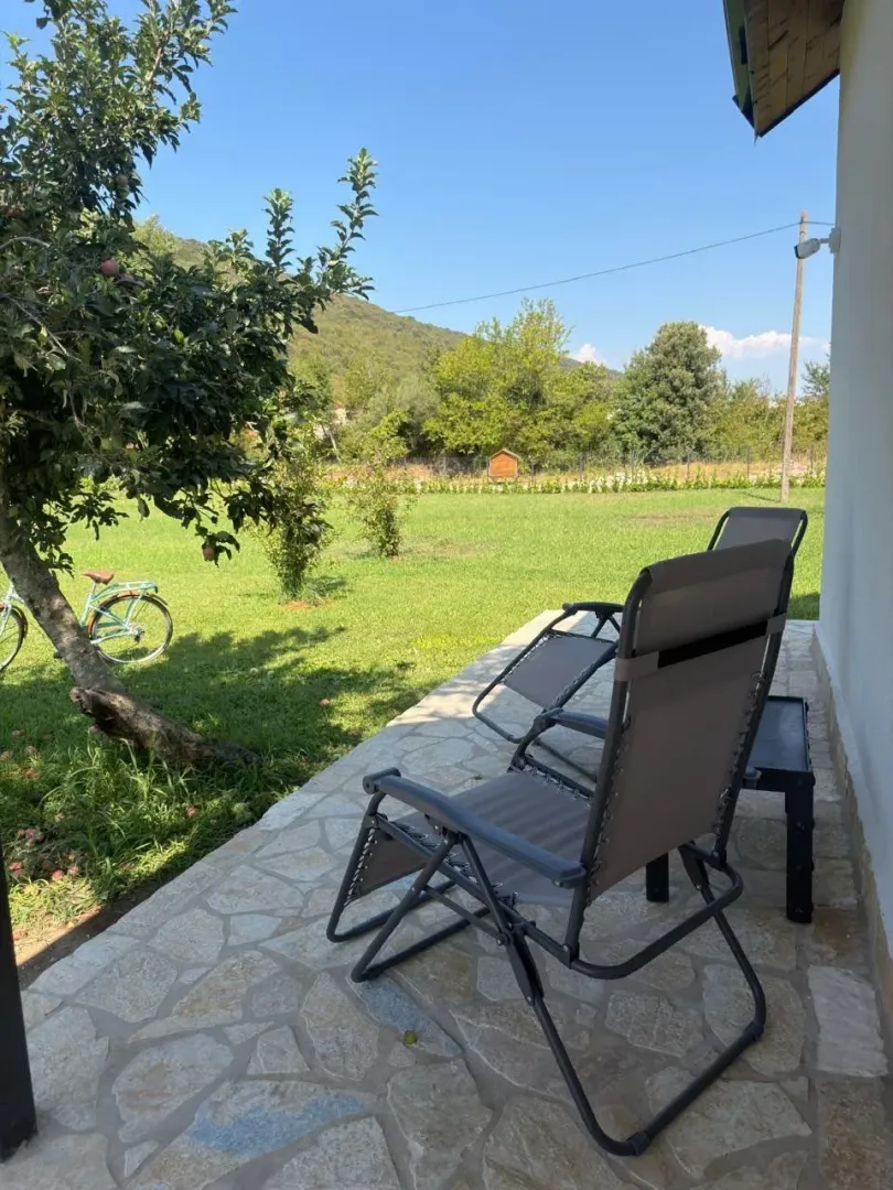 Terrace with sun loungers and a view of the landscaped yard and nature.