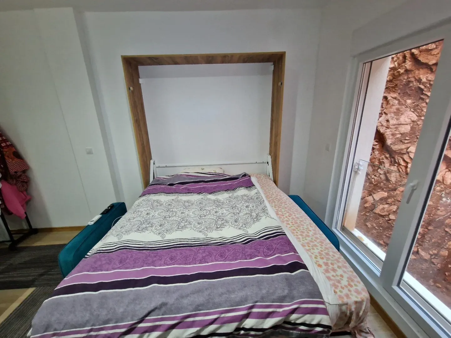 Bedroom with a fold-out bed and a window.