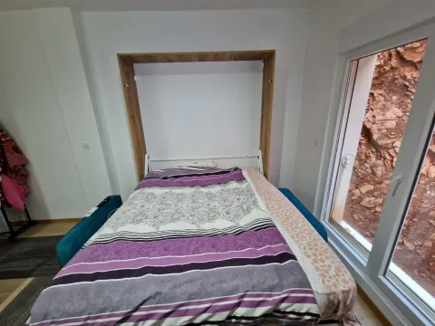 Bedroom with a fold-out bed and a window. - image 12