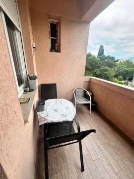 Namtještena terasa sa stolom, stolicama i pogledom na zelenilo. - image 2
