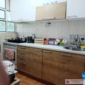 Pogled na manju kuhinju sa drvenim elementima, šporetom i sudoperom. - image 9