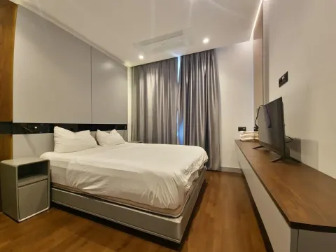 Moderna spavaća soba sa bračnim krevetom, drvenim podom i televizorom na zidu. - image 7