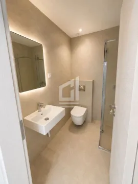 A modern bathroom equipped with a walk-in shower, washbasin, and a backlit mirror. - image 6