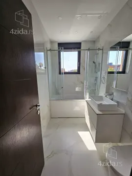 Modern bathroom with a walk-in shower, washbasin, and marble-patterned tiles. - image 21