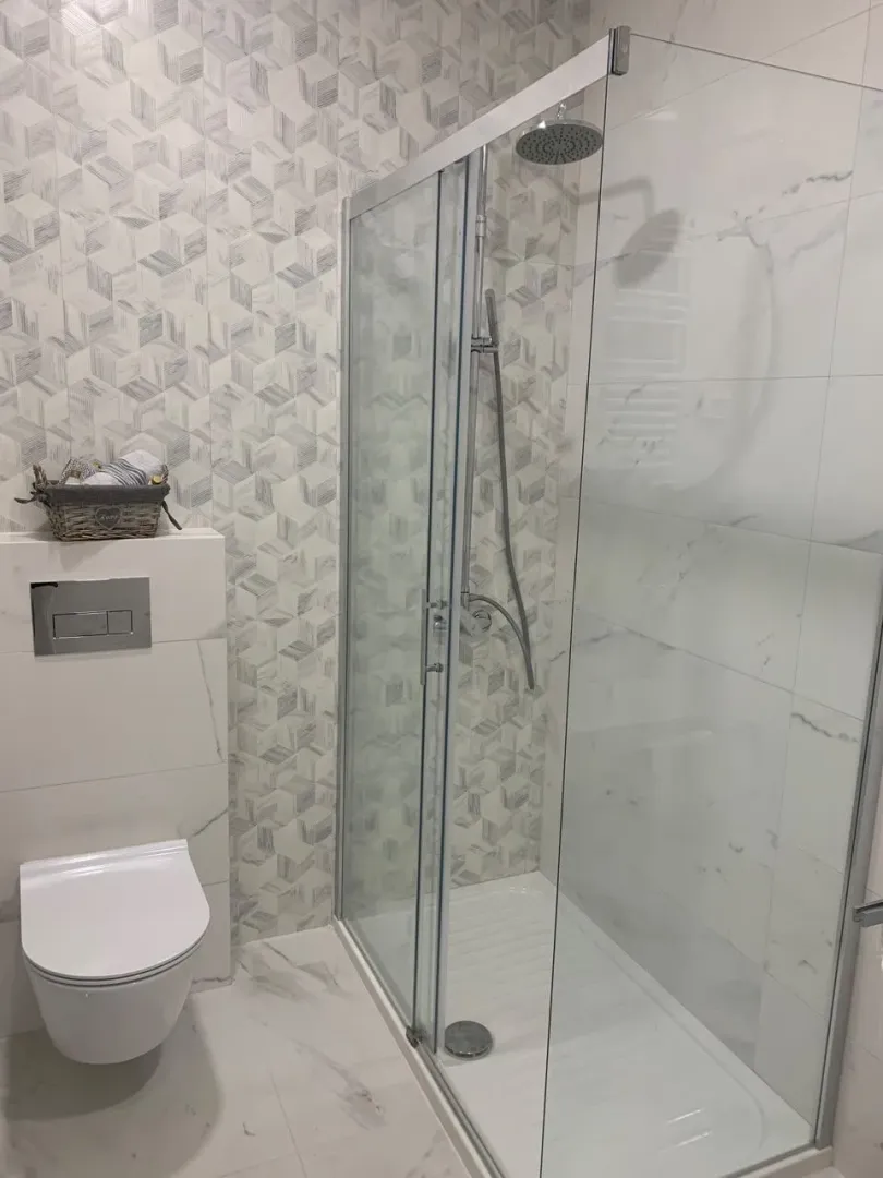 Moderne kupatilo sa tuš kabinom i ugradnom šoljom.