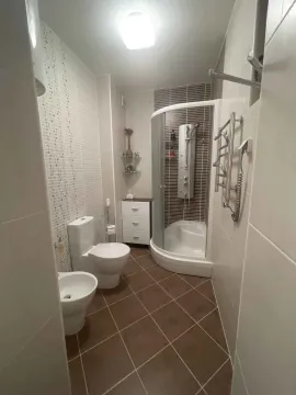 Kupatilo opremljeno tuš kabinom, wc šoljom, bideom i manjim ormarićem. - image 11