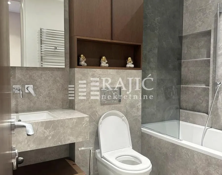 Modern equipped bathroom with a bathtub and built-in cabinet.