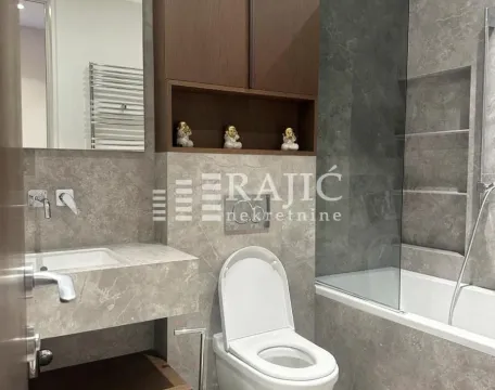Modern equipped bathroom with a bathtub and built-in cabinet. - image 9