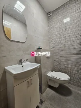 Modernly equipped bathroom with a washbasin, mirror, and toilet. - image 6