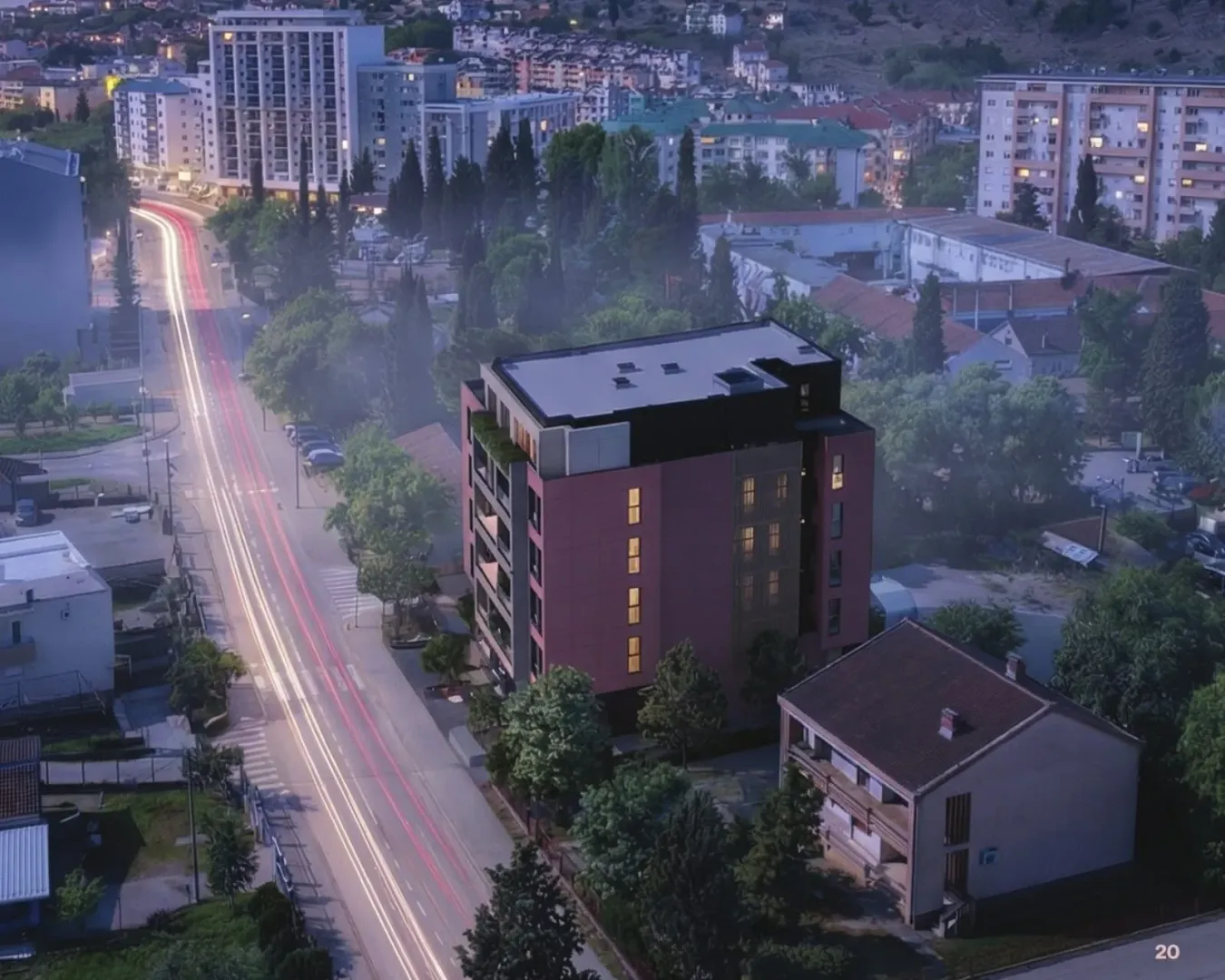 Aerial view of a residential building and the surrounding neighborhood at dusk.