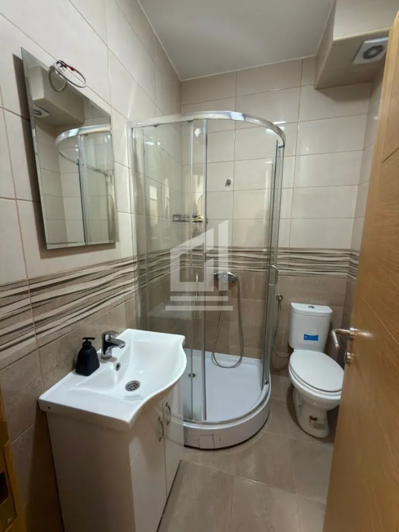 Compact bathroom with a shower cabin, washbasin, and toilet.