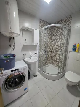 Kupatilo opremljeno tuš kabinom, umivaonikom, toaletom i veš mašinom. - image 7