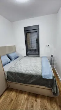 Furnished bedroom with a double bed and a window. - image 6
