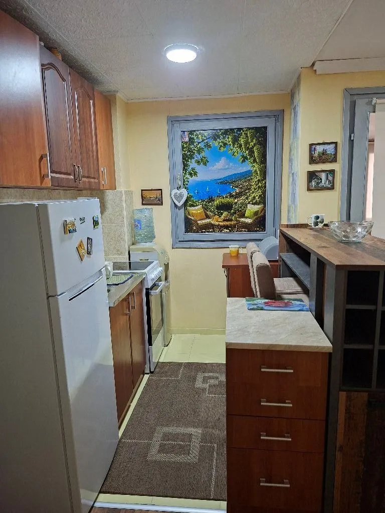 Small kitchen with wooden cabinets and a white refrigerator.