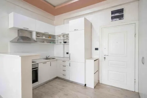 Modern white kitchen with built-in appliances and cabinetry. - image 2